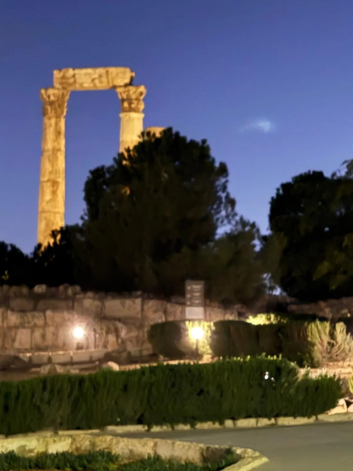 Illuminated stone columns beneath a blue evening sky